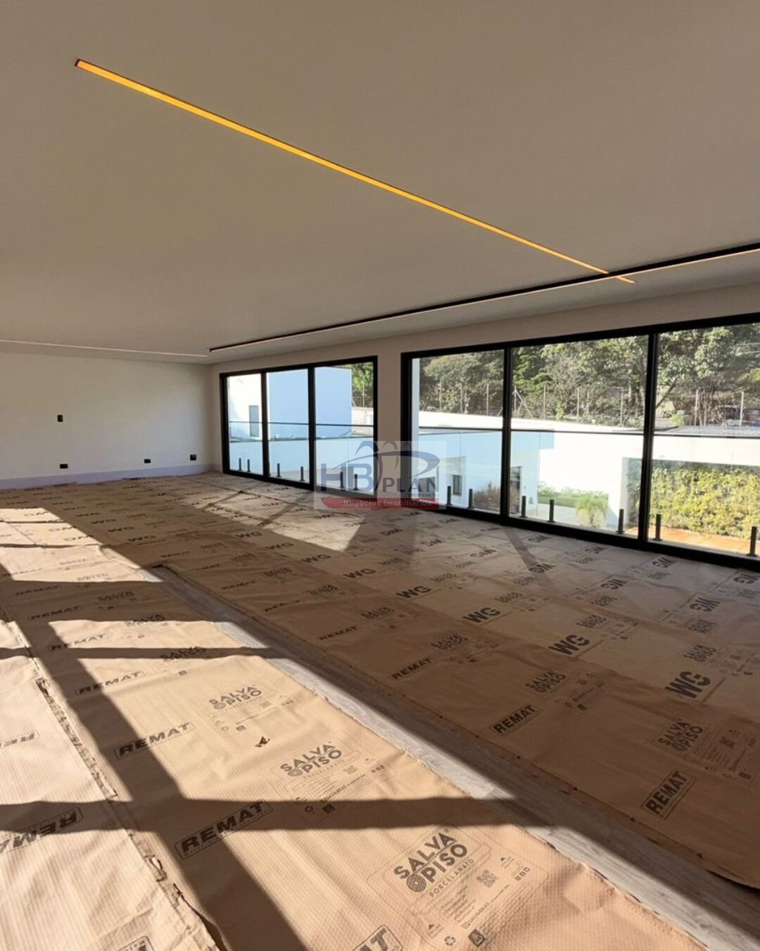 Sala ampla com janelas do piso ao teto em casa de Alphaville, Barueri